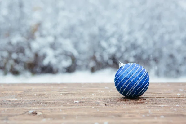 Piękne Ozdoby Świąteczne Leżą Drewnianym Stole Nad Pokrytym Śniegiem Tle — Zdjęcie stockowe