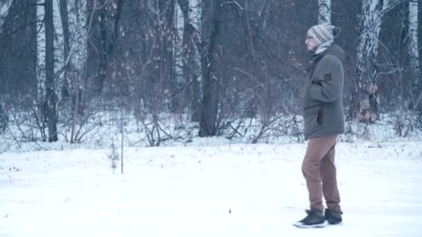 Человек, идущий в зимнем лесу — стоковое видео