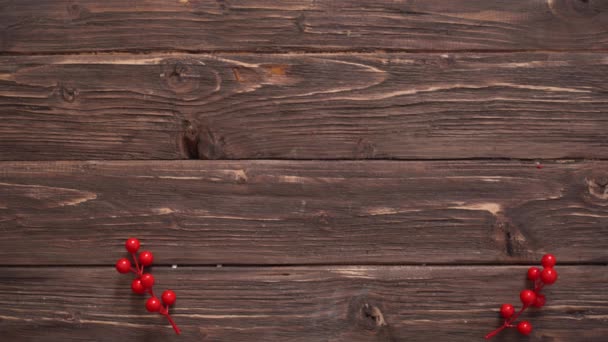 Mans ručně plní dřevěné vánoční pozadí s jedlovými větvemi, bezinky a vánoční míče. — Stock video