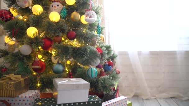 Kerstboom versierd met ballen, bloemenslingers en kerstverlichting — Stockvideo