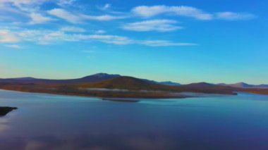 Soğuk bir sonbahar sabahında güzel dağ gölünün havadan çekilmiş videosu..