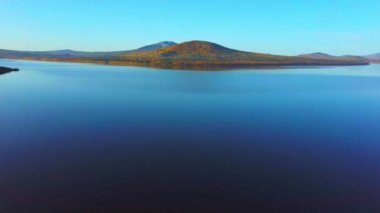 Soğuk bir sonbahar sabahında güzel dağ gölünün havadan çekilmiş videosu..