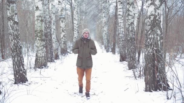 Hombre caminando en un bosque de invierno — Vídeos de Stock