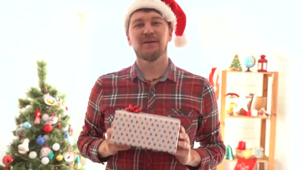 Mężczyzna w koszuli w kratę daje prezent świąteczny — Wideo stockowe