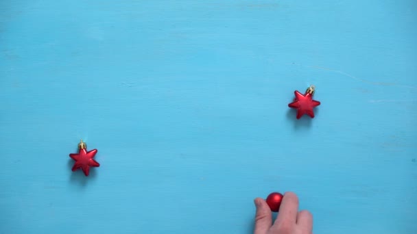 Mans hand fills wooden christmas background with fir branches, elderberries and christmas balls — Stock Video