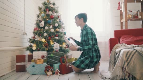 Kobieta przygotowująca się do Bożego Narodzenia i organizująca prezenty pod choinką. Zwolniony ruch — Wideo stockowe