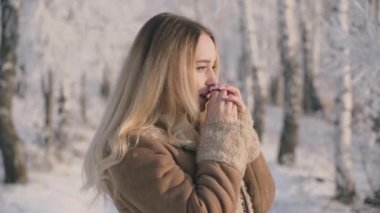 Bir kadın, güzel, soğuk bir sabahta karla kaplı ağaçlarla kış ormanlarında yürür. Yavaş Hareket