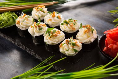 Siyah arka planda wasabi ve zencefilli suşi ruloları. Japon Doğu mutfağı.