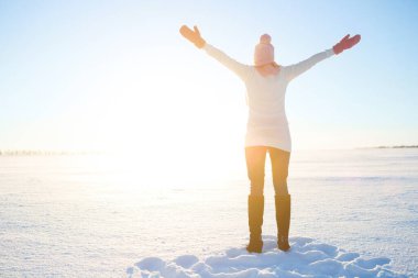 Güzel, sağlıklı, genç bir kadın kollarını kaldırarak temiz hava soluyor. Karlı dağlarda, açık havada, kış karlı bir günde..