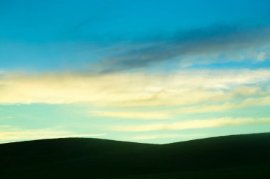 Gün batımı ve gün doğumu gökyüzü arka plan ve tepelerin silueti.