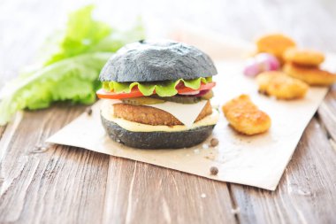 Lezzetli fast food. Siyah arka planda izole edilmiş bir siyah burger. Görünümün üstünde.