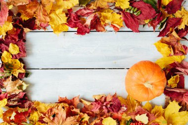 Ahşap zemin üzerinde pompa ile sonbahar yaprakları çerçevesi. Şükran Günü ve Cadılar Bayramı konsepti. Yukarıdan bak. Üst Manzara. Metin ve tasarım için boşluk kopyala