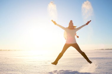 Kış arka planında kırmızı eşarbı olan mutlu bir kız.