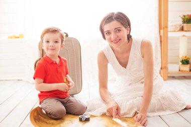 Yeni maceralara ve keşiflere atılmak. Mutlu anne ve oğlu evde oturma odasında oturuyor ve haritada seyahat için bir yer seçiyor. Çocuk Seyahati