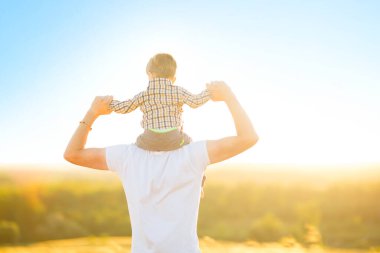 Sıcak ve güneşli bir günde parkta mutlu bir baba ve oğul. Aile ve aşk kavramı
