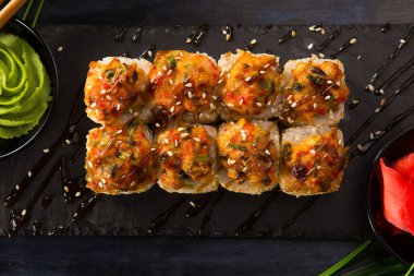 Siyah arka planda wasabi ve zencefilli fırında suşi ruloları. Japon Doğu mutfağı.