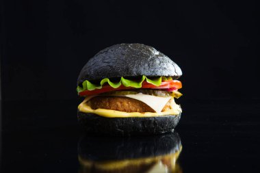 Lezzetli fast food. Siyah arka planda modern siyah burger. Renkli resim