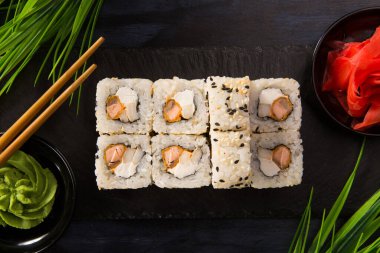 Siyah arka planda wasabi ve zencefilli suşi ruloları. Japon Doğu mutfağı.
