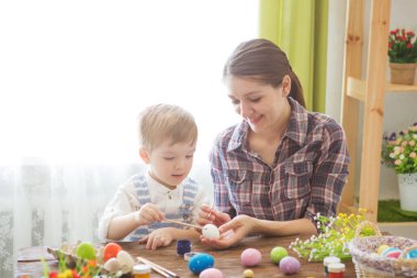 Paskalya yumurtası boyarken mutlu zamanlar. Paskalya konsepti. Mutlu anne ve tatlı çocuğu yumurtaları boyayarak Paskalya için hazırlanıyorlar..