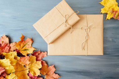 Yıllanmış ahşap tahtaların üzerinde sonbahar yeşillikleri olan el yapımı hediye kutuları. Yukarıdan bak. Üst Manzara. Metin ve tasarım için boşluk kopyala