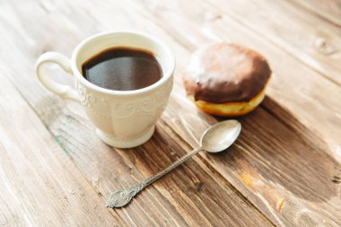 Kuru üzümlü lezzetli çörekler ve kahverengi ahşap bir masada bir fincan kahve. Taze fırın. Kahvaltı. Ekmek. en üstteki görünüm