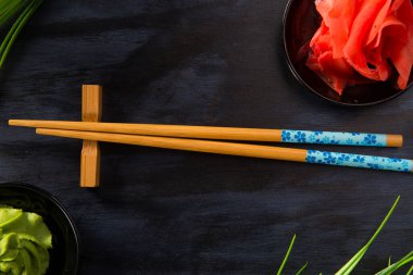 Siyah arka planda wasabi olan Çin çubukları.