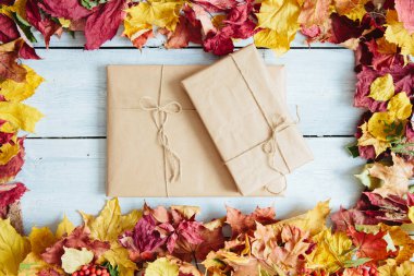 Yıllanmış ahşap tahtaların üzerinde sonbahar yeşillikleri olan el yapımı hediye kutuları. Yukarıdan bak. Üst Manzara. Metin ve tasarım için boşluk kopyala