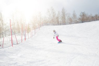 Buz gibi kış gününde, yamaçlarda kadın snowboardcu. Kar kenarındaki güzel kız.