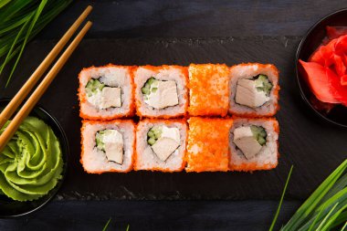 Siyah arka planda wasabi ve zencefilli suşi ruloları. Japon Doğu mutfağı.