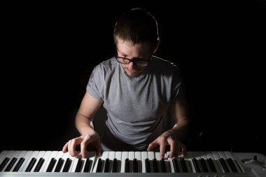 Klavyeci koyu arkaplanda Synthesizer 'da çalıyor. 