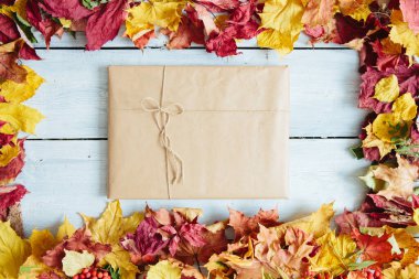 Yıllanmış ahşap tahtaların üzerinde sonbahar yeşillikleri olan el yapımı hediye kutuları. Yukarıdan bak. Üst Manzara. Metin ve tasarım için boşluk kopyala