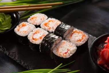 Siyah arka planda wasabi ve zencefilli suşi ruloları. Japon Doğu mutfağı.