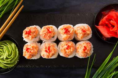 Siyah arka planda wasabi ve zencefilli suşi ruloları. Japon Doğu mutfağı.
