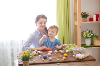 Bir anne ve oğlu Paskalya yumurtası boyuyor. Mutlu aile Paskalya için hazırlanıyor. Mutlu Paskalyalar.