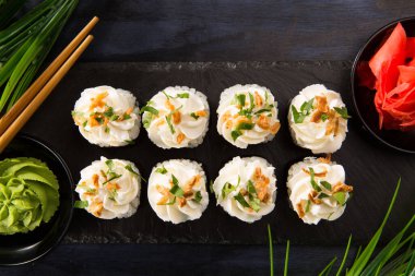 Siyah arka planda wasabi ve zencefilli suşi ruloları. Japon Doğu mutfağı.