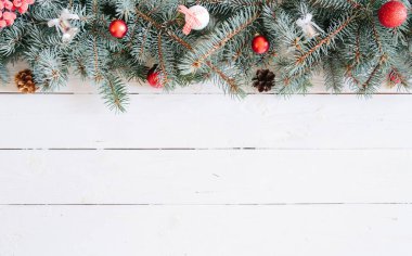 Tahta zemin üzerinde noel ağacı ve fotokopi alanı. Bulanık Noel arkaplanı, köknar dalları, peri ışıkları ve beyaz tahta üzerinde noel süslemeleri.