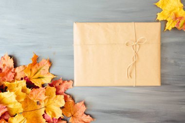 Yıllanmış ahşap tahtaların üzerinde sonbahar yeşillikleri olan el yapımı hediye kutuları. Yukarıdan bak. Üst Manzara. Metin ve tasarım için boşluk kopyala