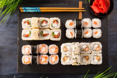 Siyah arka planda wasabi ve zencefilli suşi ruloları. Japon Doğu mutfağı.