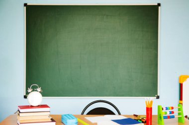 Öğrenci veya öğretmen çalışma alanı arkaplanda bir karatahta ile