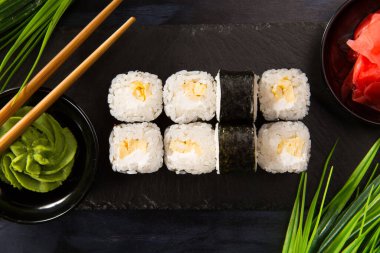 Siyah arka planda wasabi ve zencefilli suşi ruloları. Japon Doğu mutfağı.