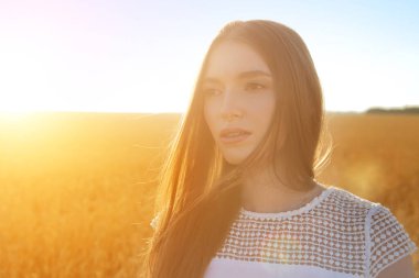Altın buğday tarlasında genç mutlu kızın portresi.