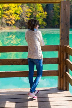 Dağlardaki mavi gölün yanında bir kız.