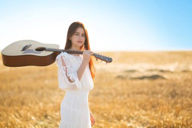 Yaz parkında akustik gitarlı bir kadın..