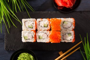 Siyah arka planda wasabi ve zencefilli suşi ruloları. Japon Doğu mutfağı.