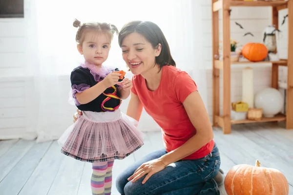 母と子供の幸せな家族は家を飾るためにハロウィーンの準備をします — ストック写真