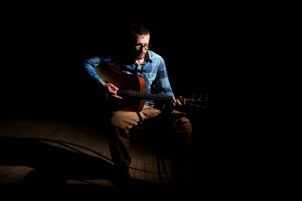 Молодий Музикант Плетеній Сорочці Грає Гітарі Співає Темному Фоні — стокове фото