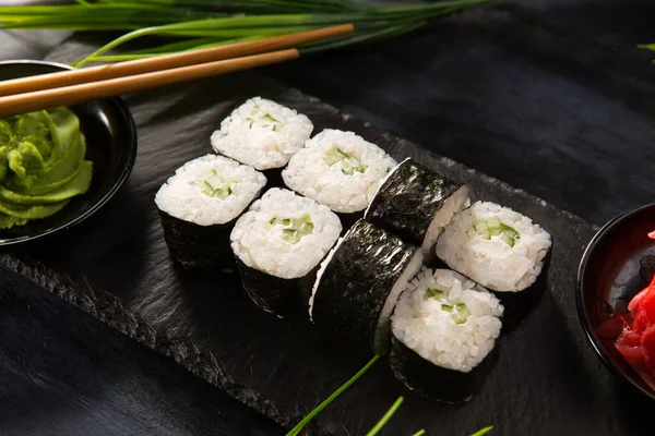 Siyah arka planda wasabi ve zencefilli suşi ruloları. Japon Doğu mutfağı.