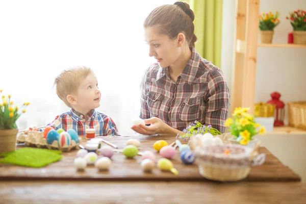 Paskalya konsepti. Mutlu anne ve tatlı çocuğu yumurtaları boyayarak Paskalya için hazırlanıyorlar..