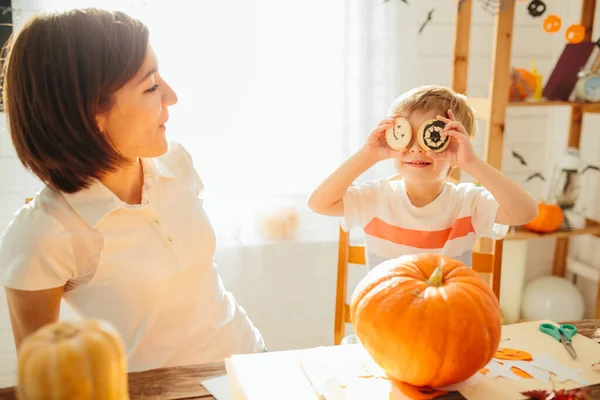 母親と息子は自宅のキッチンでカボチャと楽しみを持っています ハッピーハロウィンのコンセプト — ストック写真