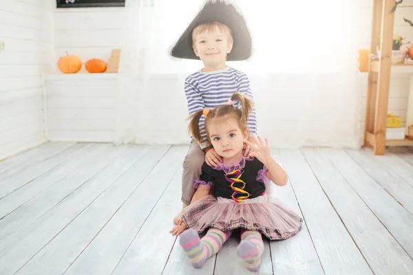 海賊の衣装を着た少年と魔女の衣装を着た少女は自宅でハロウィンを祝います — ストック写真